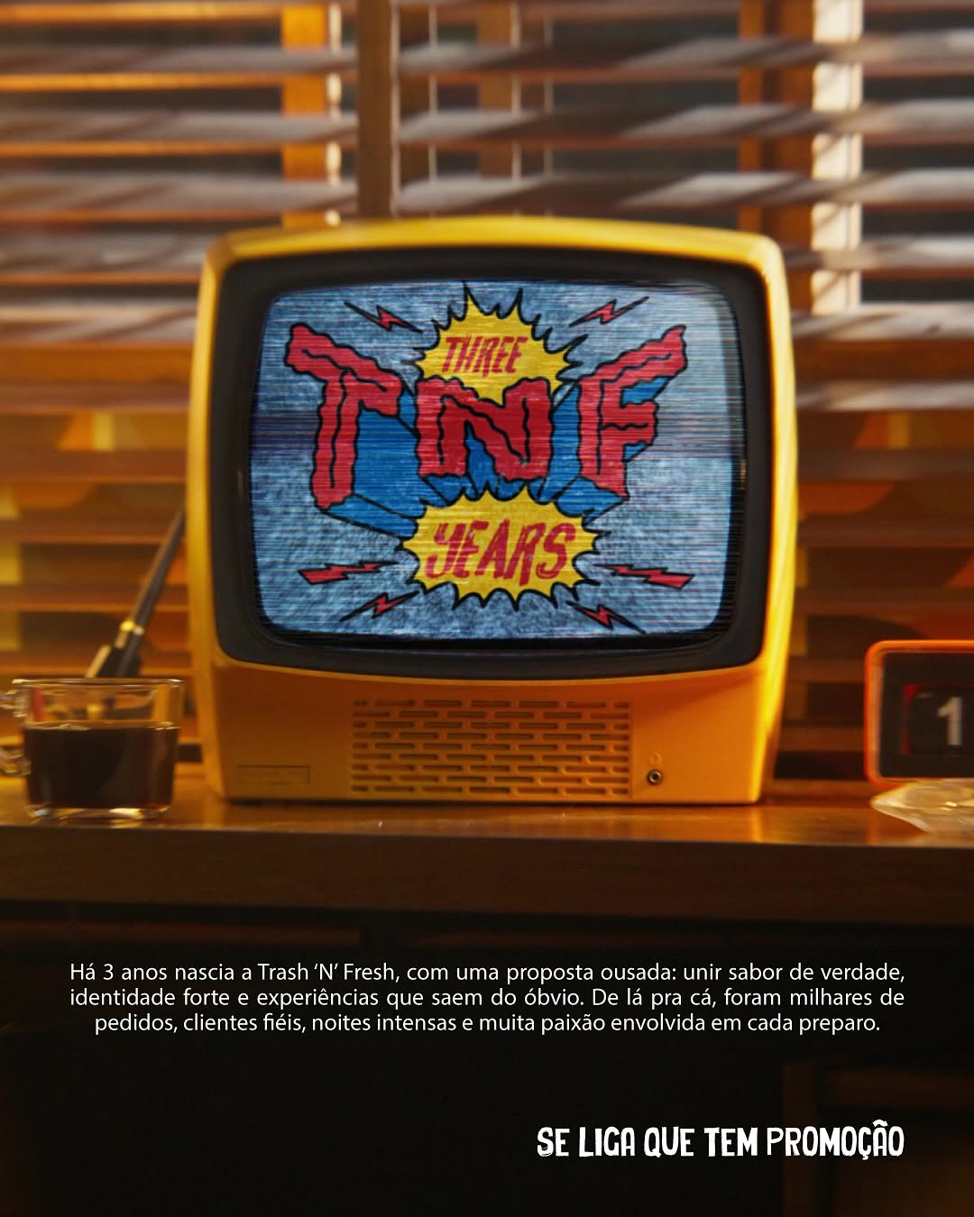TV de tubo amarela mostrando a arte em quadrinhos TNF Three Years, com explosão e raios em vermelho, azul e amarelo
